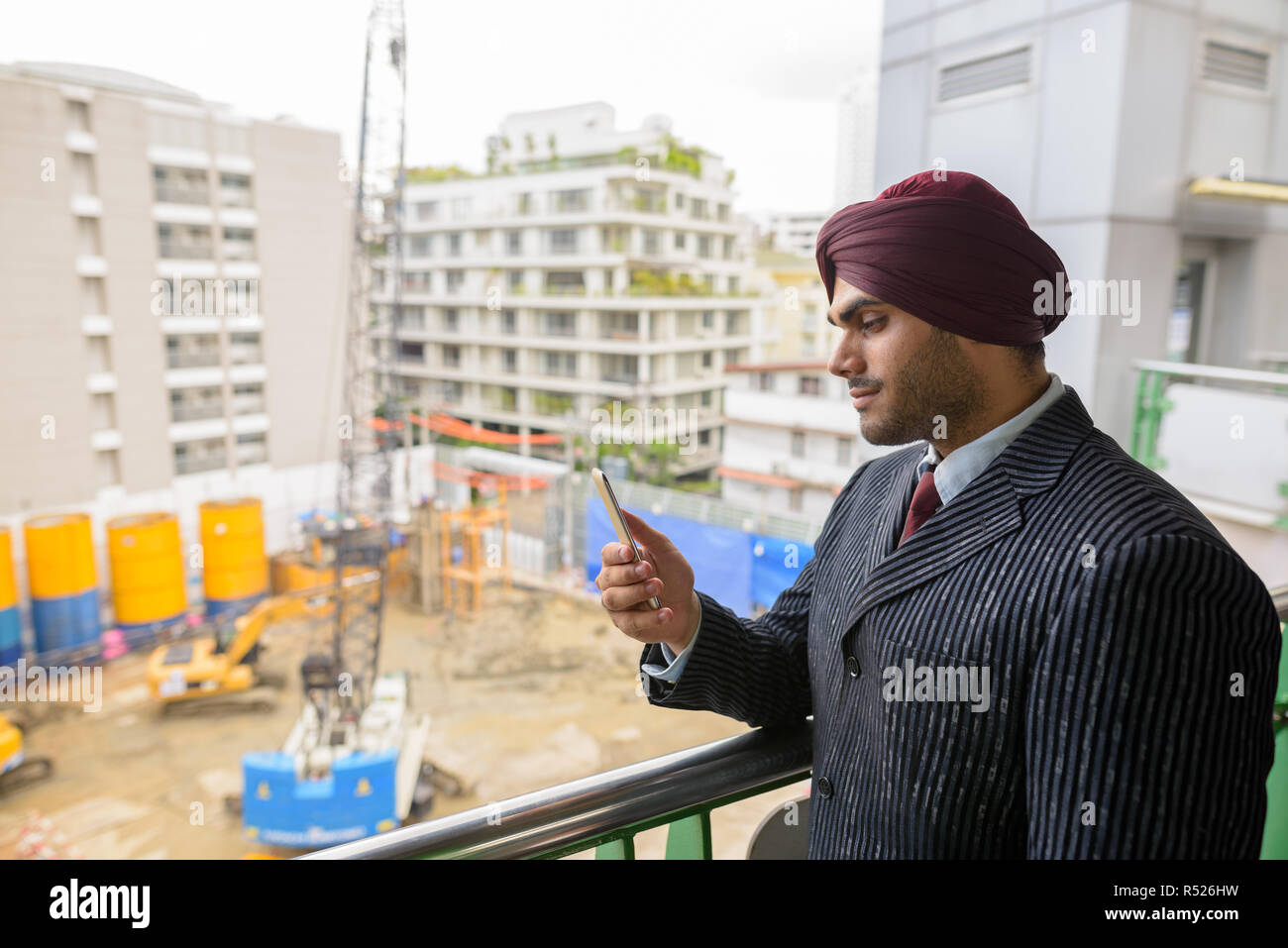 Commerciante indiano guardando alla costruzione del sito di sviluppo con grattacieli Foto Stock