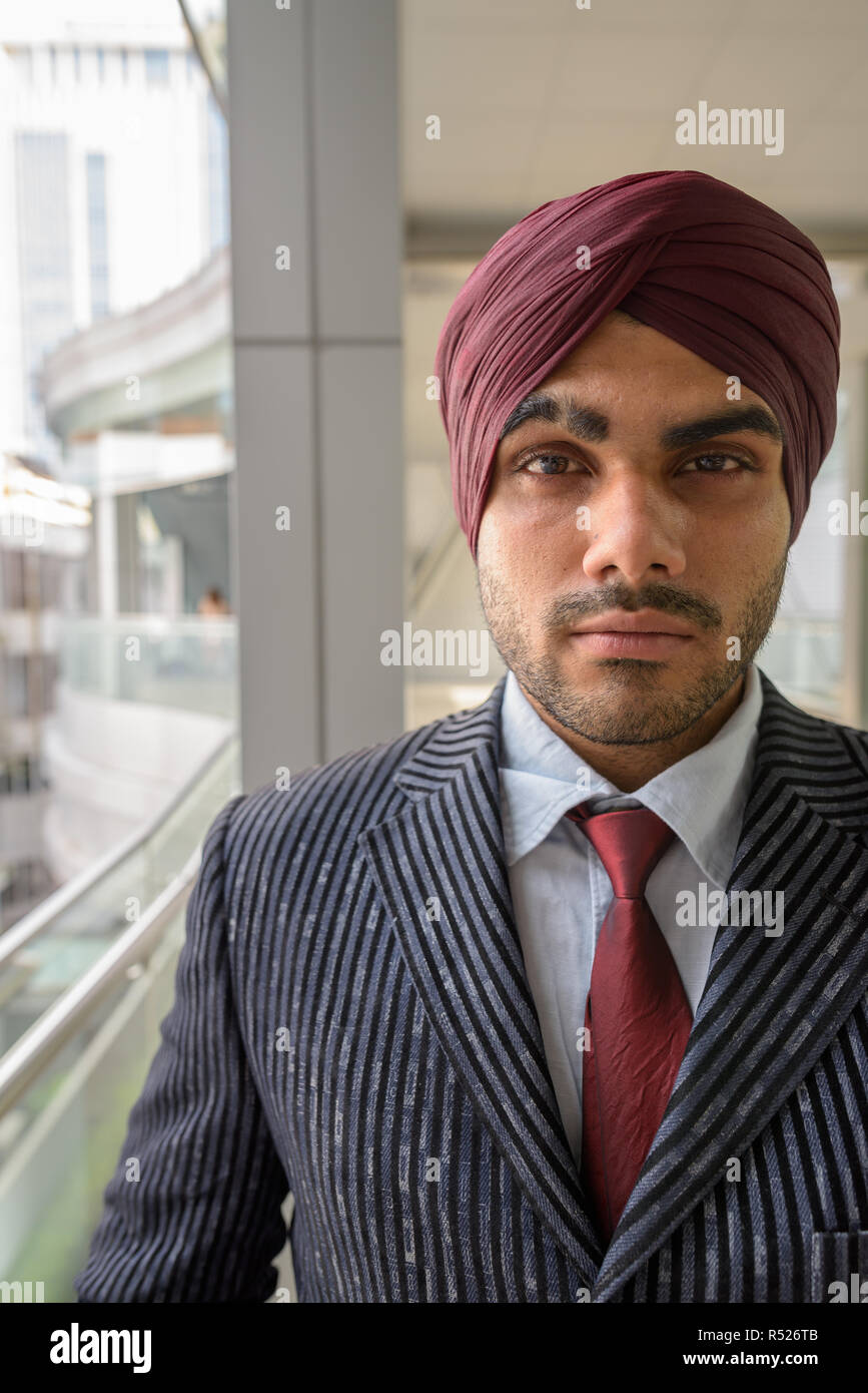 Ritratto di commerciante indiano faccia con turbante all aperto in città Foto Stock