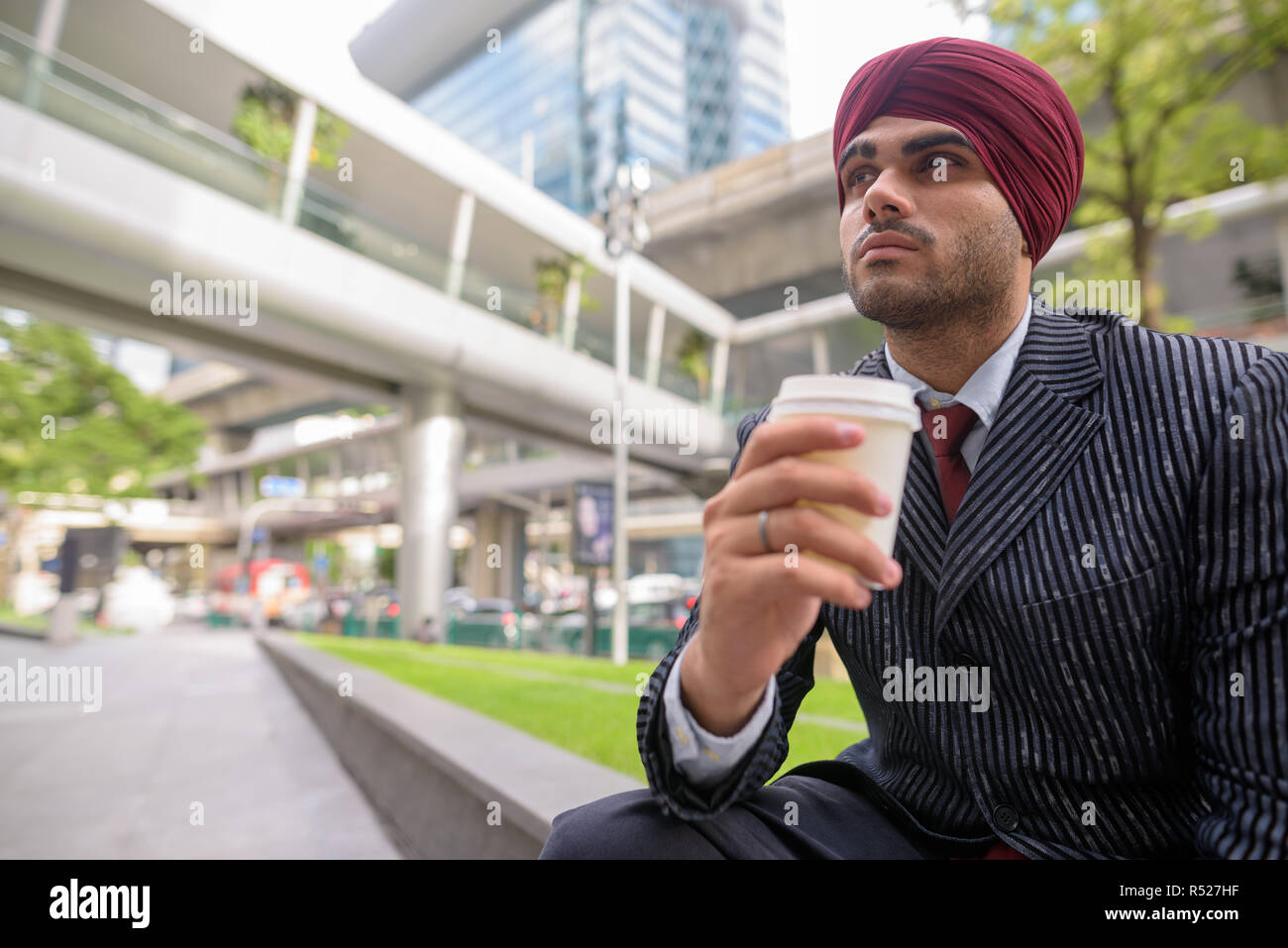 Commerciante indiano seduti all'aperto in città pur avendo pausa caffè Foto Stock