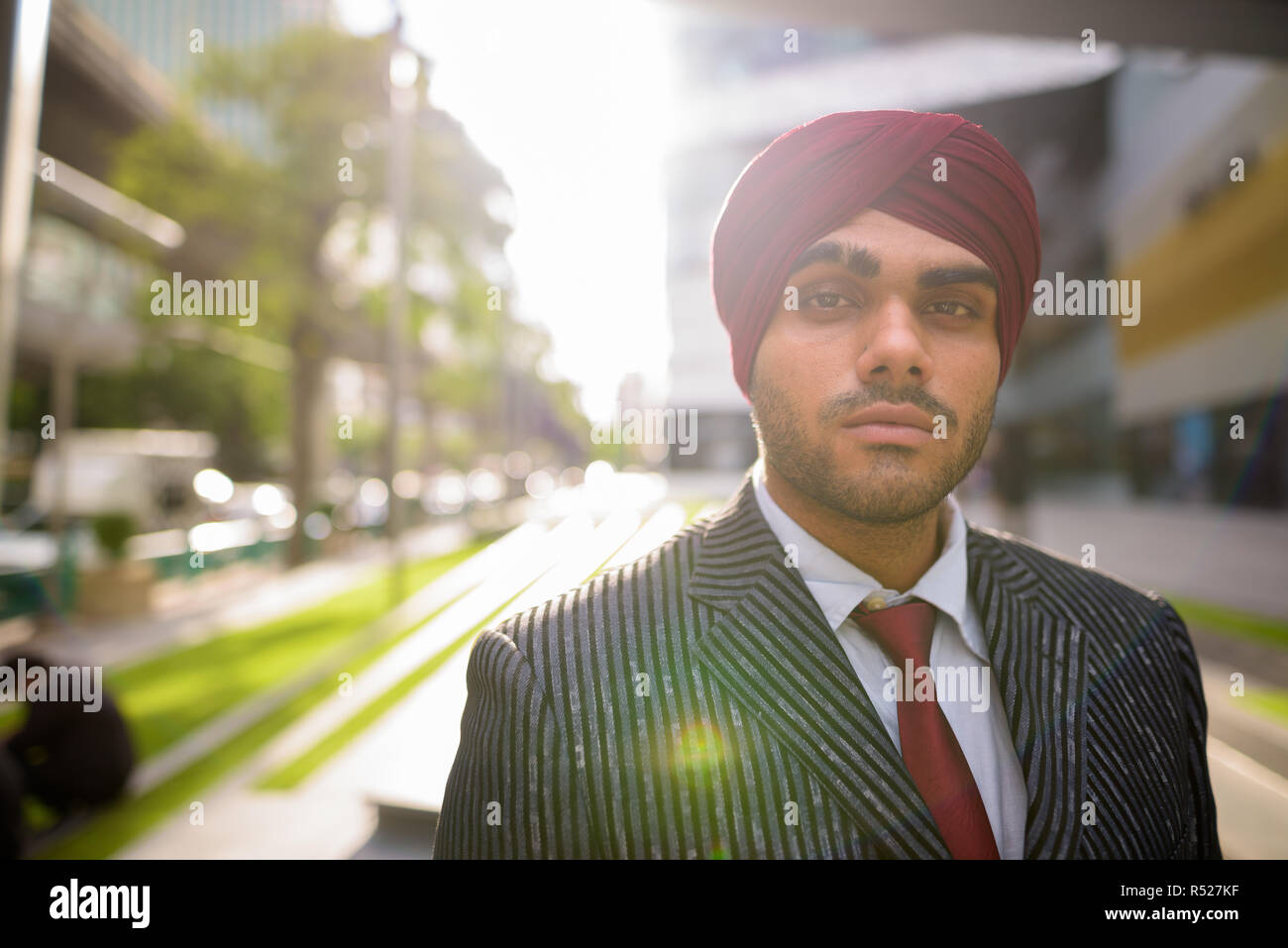 Ritratto di commerciante indiano all'aperto in città con lens flare Foto Stock