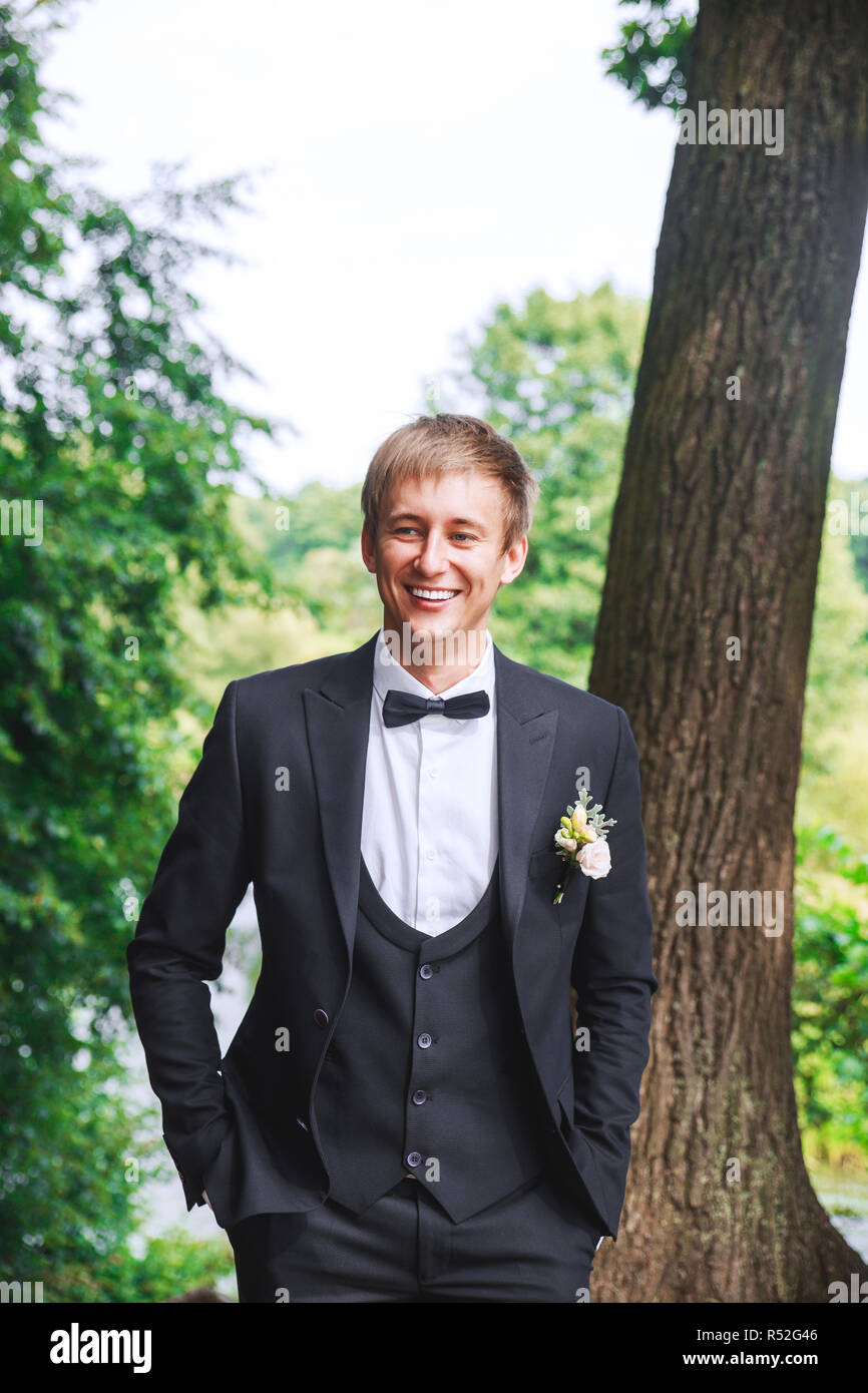 Sposo a wedding tuxedo sorridente e in attesa per la sposa. Ricco sposo a giorno di nozze. Elegante lo sposo in costume e bow tie-in. Foto Stock