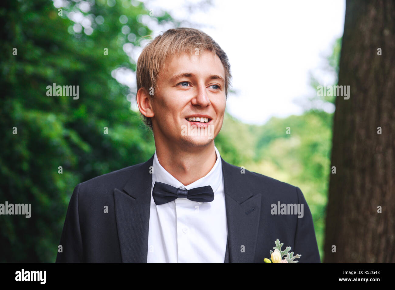 Sposo a wedding tuxedo sorridente e in attesa per la sposa. Ricco sposo a giorno di nozze. Elegante lo sposo in costume e bow tie-in. Foto Stock