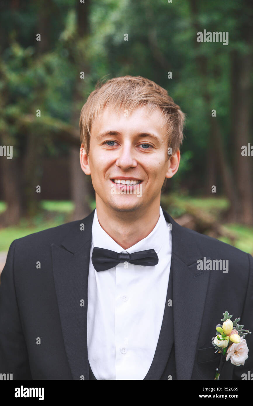 Elegante sposi matrimonio foto. Bello ed elegante per lo sposo. Lo sposo in posa di parcheggiare su un giorno di nozze. Foto Stock