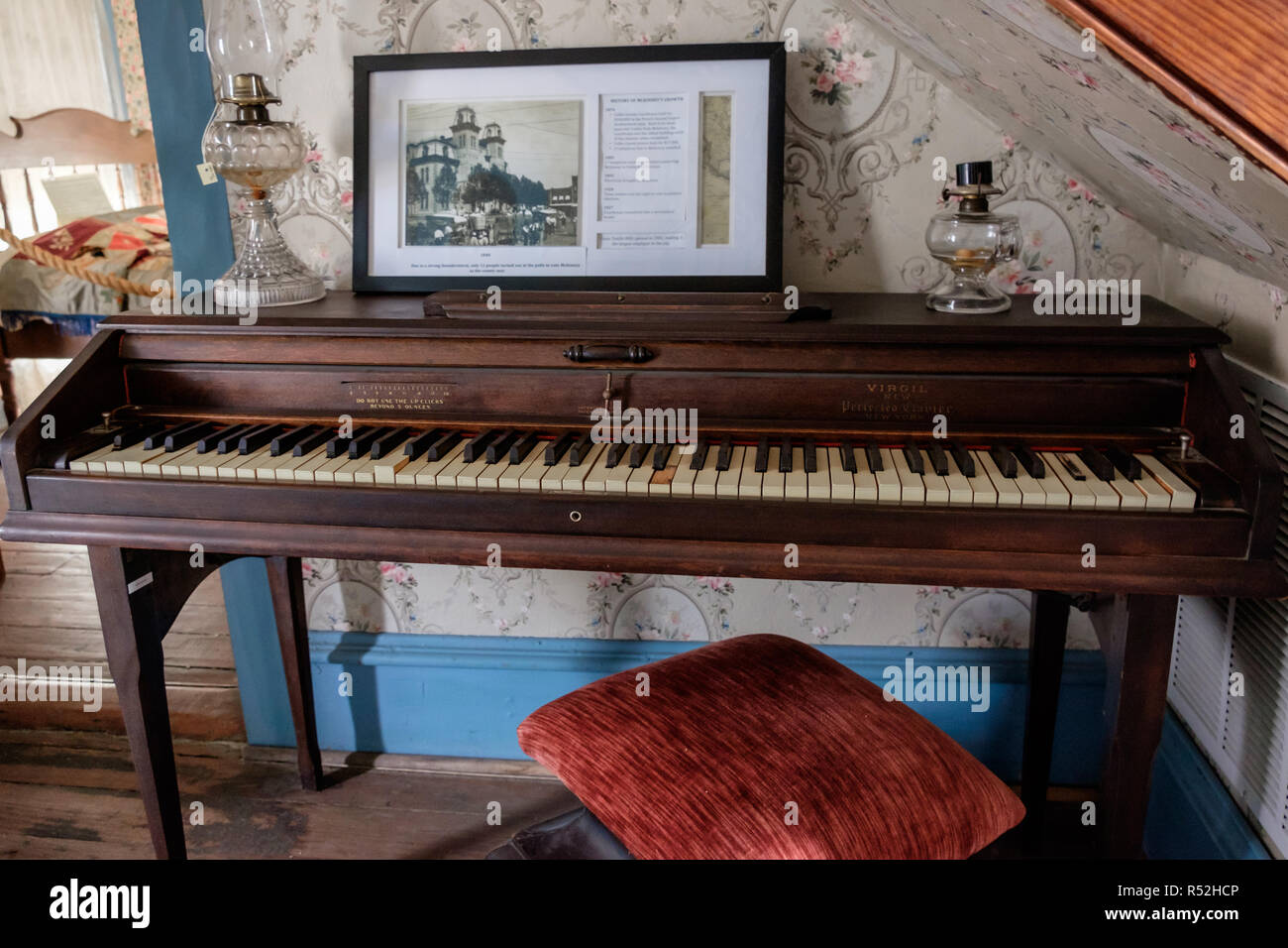 Virgilio antico pianoforte nella storica casa texano con vintage foto incorniciate, ornati salone di vetro lampade a olio e vintage carta da parati a fiori. McKinney,Texas. Foto Stock