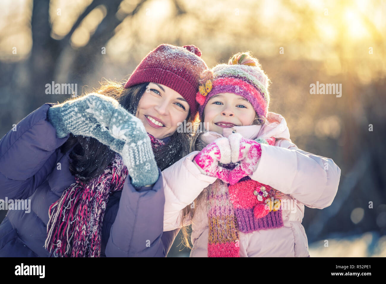 Bambina e sua madre per giocare all'aperto presso soleggiata giornata invernale Foto Stock