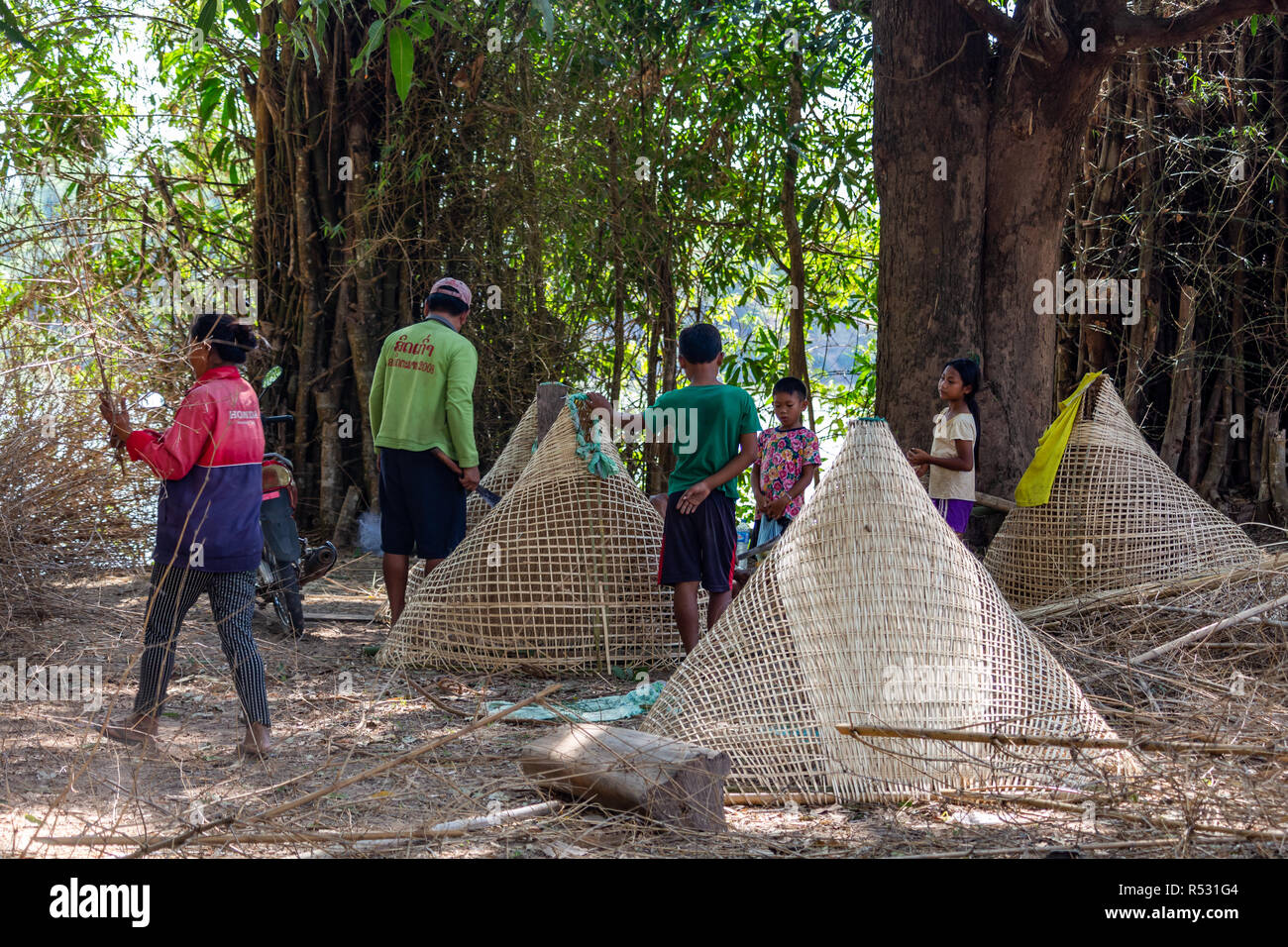 Don Daeng, Laos - Aprile 27, 2018: persone locali di produzione artigianale di grandi trappole di bambù Foto Stock