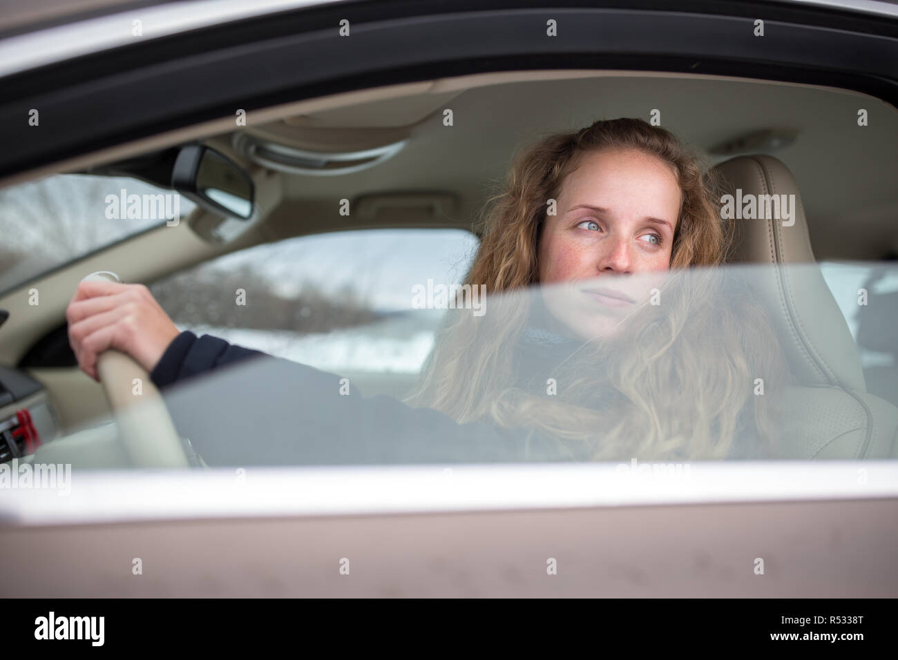 Piuttosto giovane donna alla guida la sua nuova vettura (SHALLOW DOF dai toni di colore immagine) Foto Stock