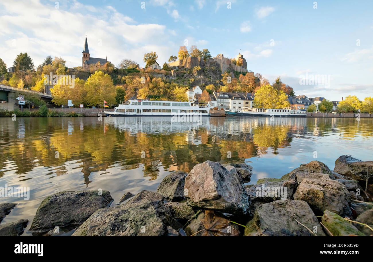 Autunno cityscape di Saarburg, Germania con le rovine del castello di montagna. Vista dal lato del fiume Saar. Foto Stock
