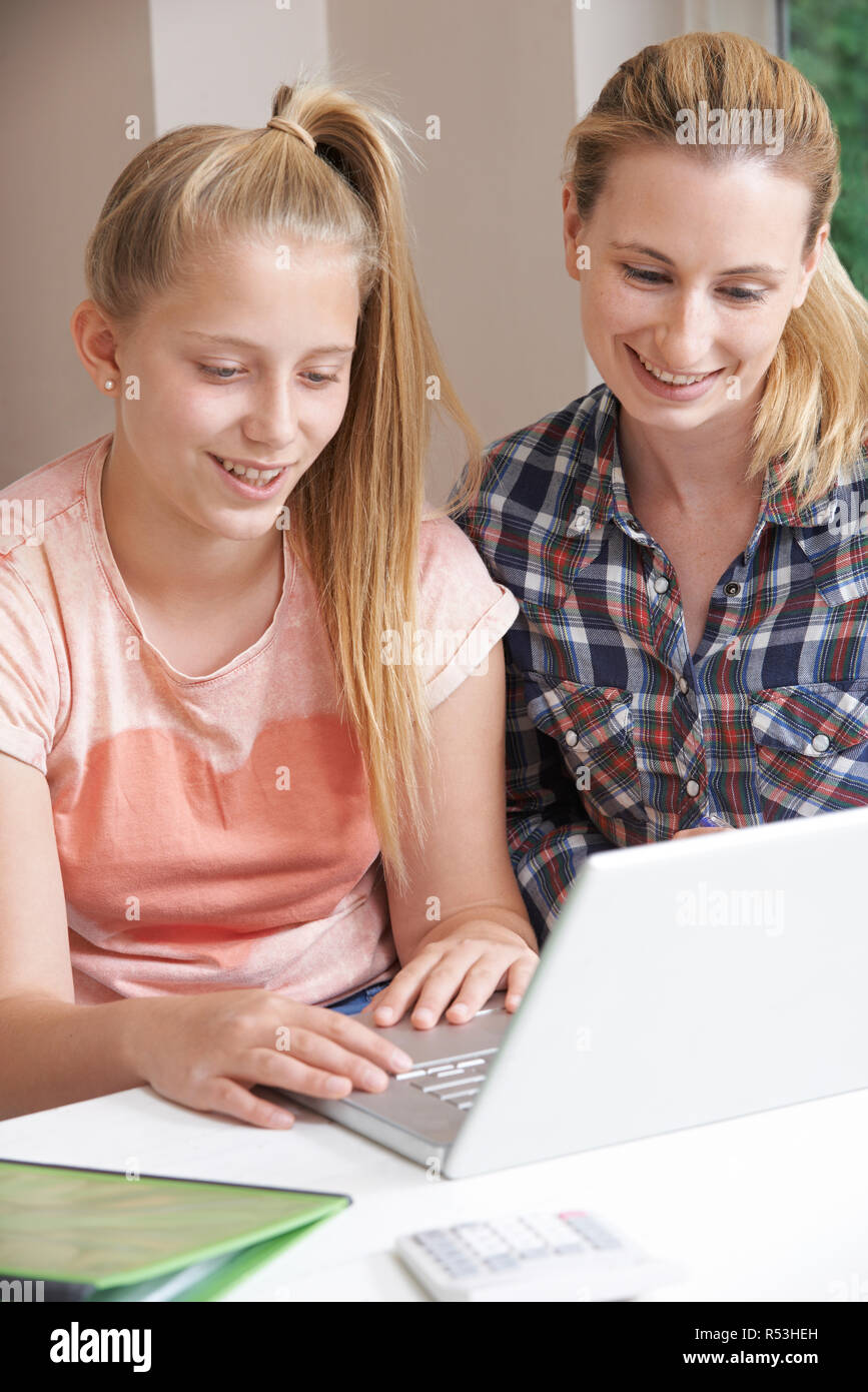 Femmina Tutor Home aiutando la ragazza con gli studi che utilizzano computer portatile Foto Stock