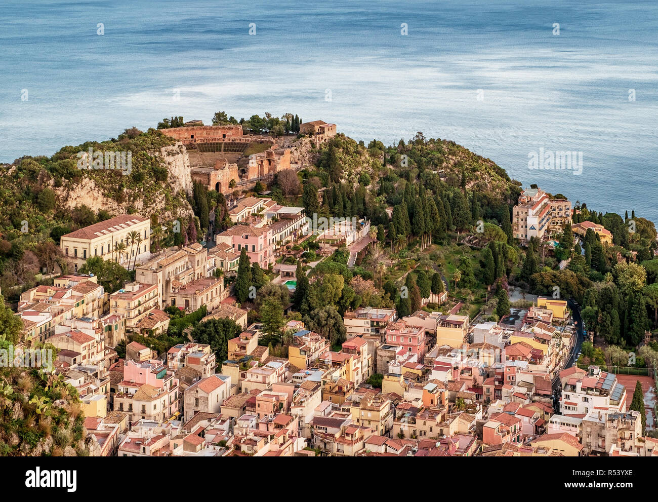 L'antico teatro greco al di sopra del villaggio di Taormina, provincia di Messina, Sicilia, Italia. Mare Mediterraneo sullo sfondo. Foto Stock