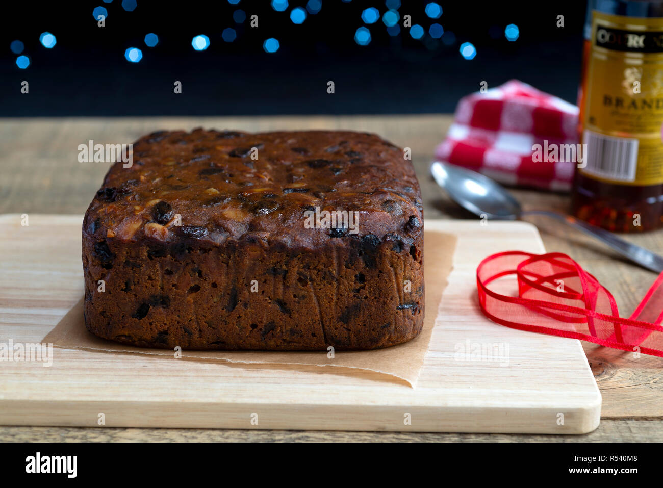 La preparazione di 'alimentazione' un frutto ricco di torta di Natale versando il brandy su di esso. Foto Stock
