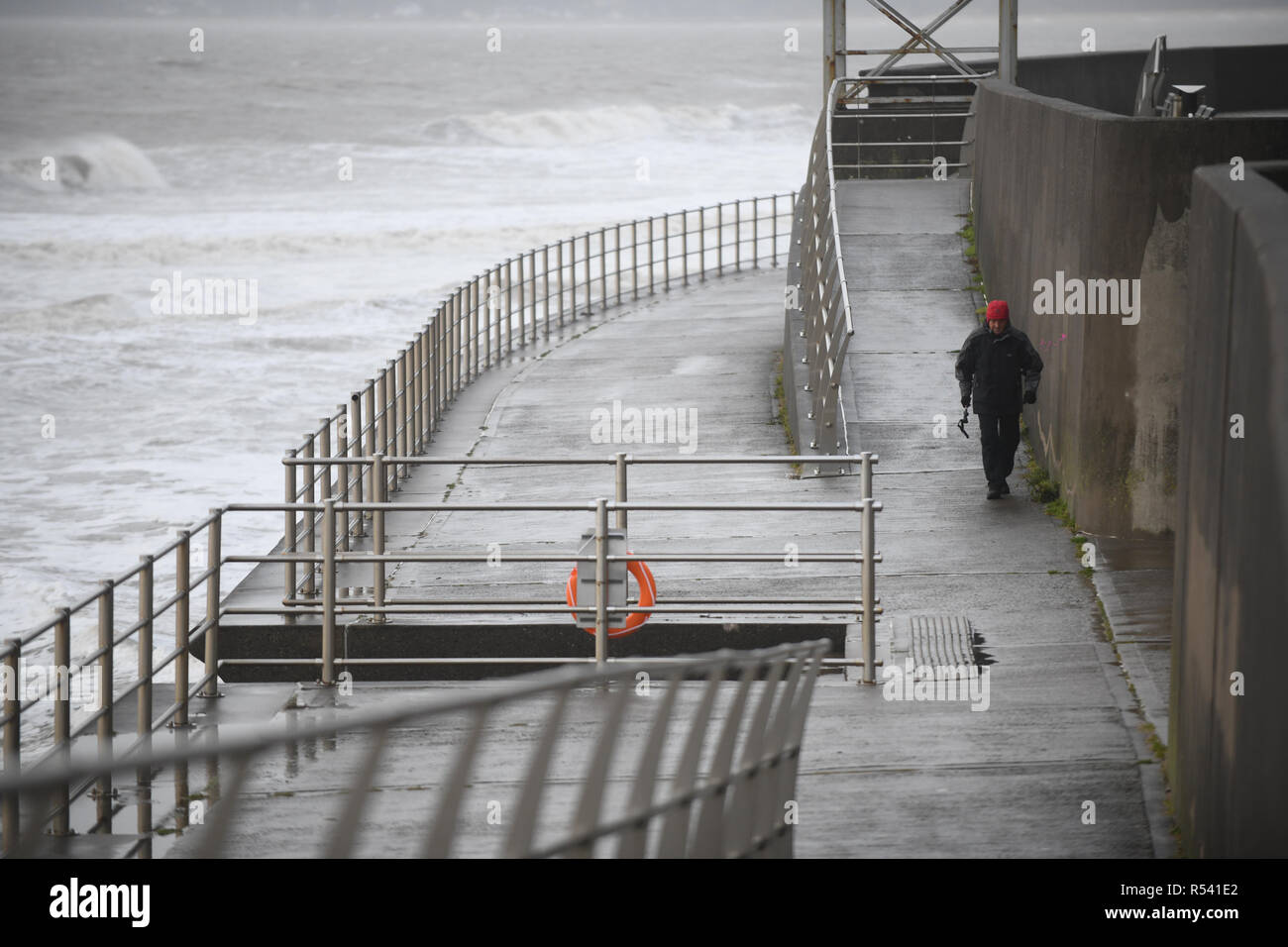 Swansea, South Wales, Regno Unito. Il 29 novembre 2018, un uomo cammina lungo il lungomare di Swansea come tempesta Diana colpisce il Galles del Sud Costa come esso attraversa il Regno Unito portando i forti venti e pioggia. Credito : Robert Melen/Alamy Live News. Foto Stock