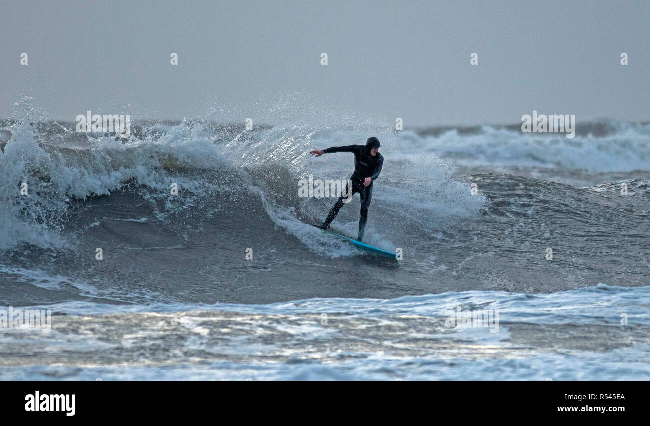 Swansea, Regno Unito. 29 Nov, 2018. Regno Unito: Meteo un surfista rende la maggior parte delle onde a Langland Bay vicino a Swansea questo pomeriggio come tempesta Diana pastelle il Regno Unito con forti venti e piogge. Credito: Phil Rees/Alamy Live News Foto Stock