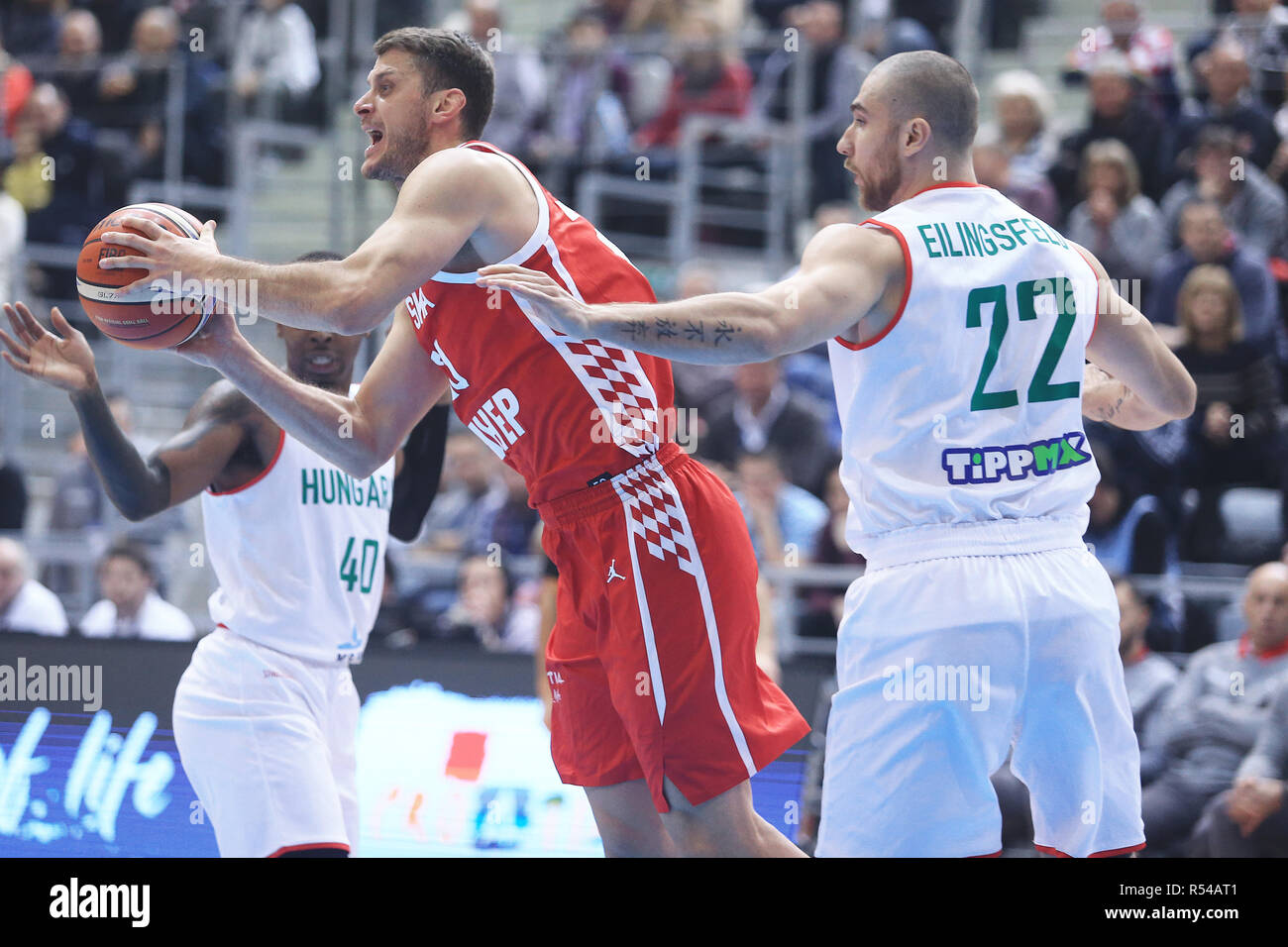 (181130) -- Osijek, nov. 30, 2018 (Xinhua) -- Marin Rozic (C) della Croazia con vies Janos Eilingsfeld di Ungheria durante la FIBA World Cup qualificazioni match tra Croazia e Ungheria a osijek, Croazia, su nov. 29, 2018. La Croazia ha vinto 74-69. Foto Stock