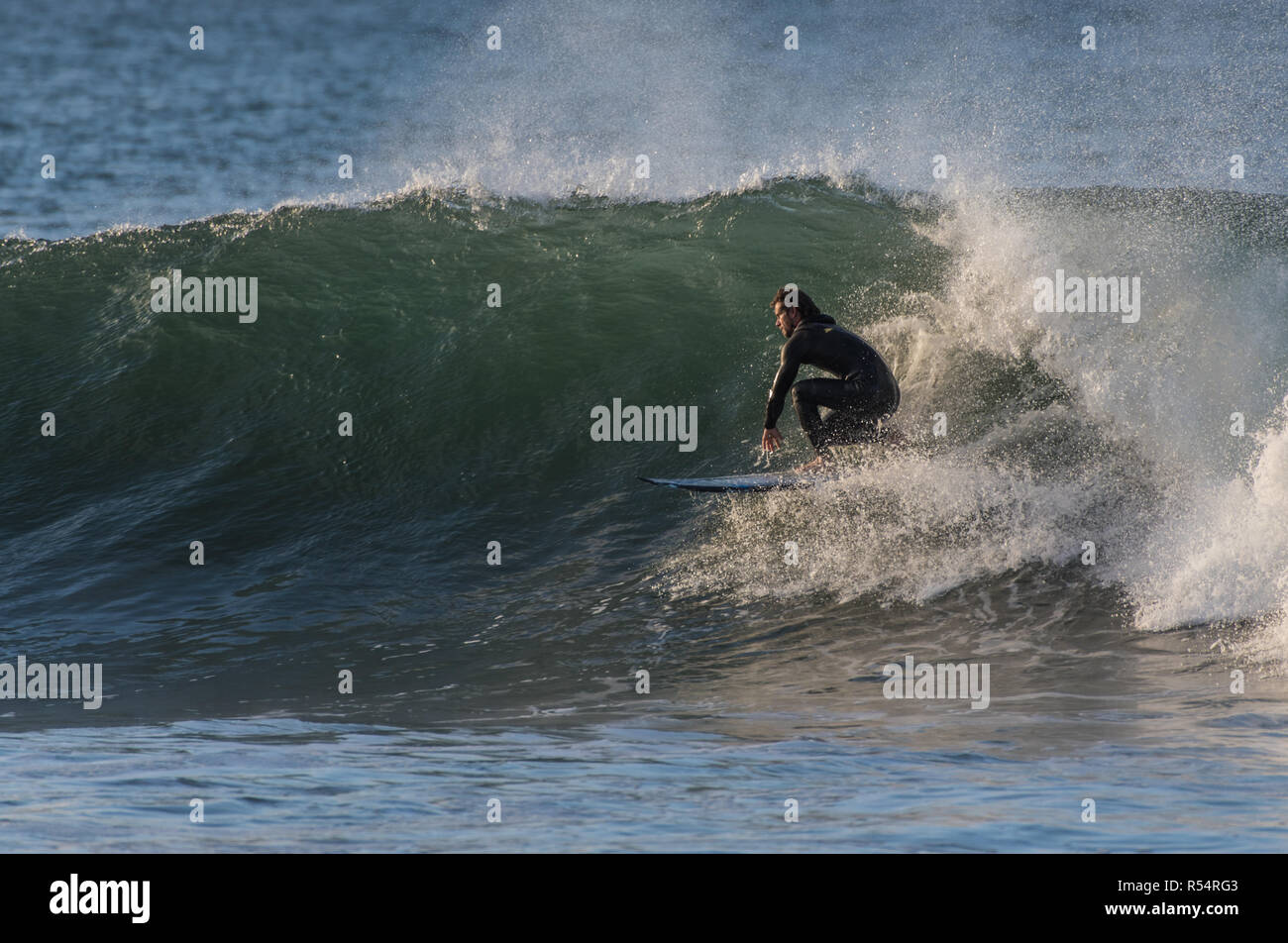 Surfer in bassa crouch come egli scende in un 6 piedi in onda Ventura, California, Stati Uniti d'America durante il tardo autunno si rigonfiano il 28 novembre 2018. Foto Stock