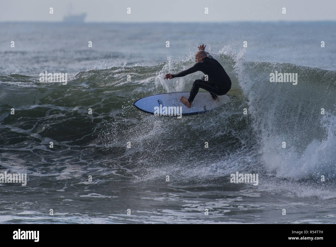 Surfer in posizione bilanciata come egli velocità attraverso thw faccia d'onda in Ventura, California, Stati Uniti d'America durante il tardo autunno si rigonfiano il 28 novembre 2018. Foto Stock
