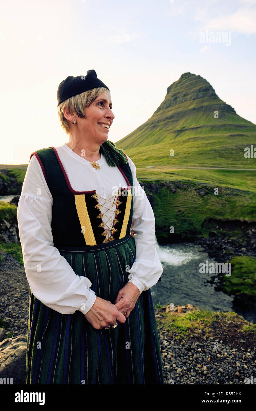 Un locale islandese di donna che indossa Upphlutur tradizionale abito nazionale a Mt Kirkjufell & Kirkjufellsfoss in Grundarfjörður - Snaefellsnes Islanda Europa Foto Stock