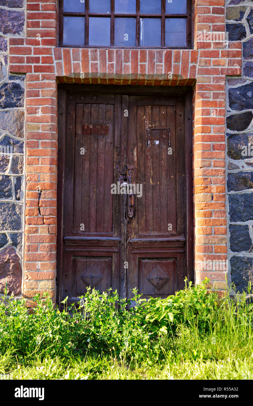 Trascurare la singola porta di legno nella vecchia casa di città Foto Stock