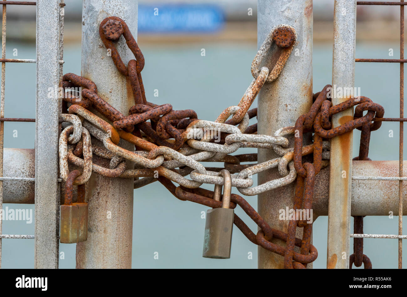 Vecchio arrugginito catene con un lucchetto di fissaggio in acciaio zincato cancello chiuso. sicurezza e lucchetti con catene corrosi. Foto Stock