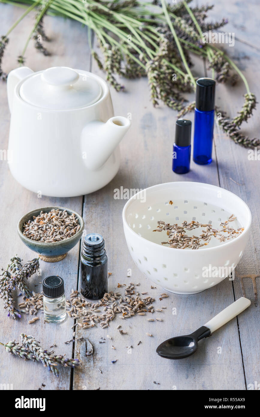 Olio essenziale di lavanda (Lavandula sp.)e tè alle erbe. Foto Stock