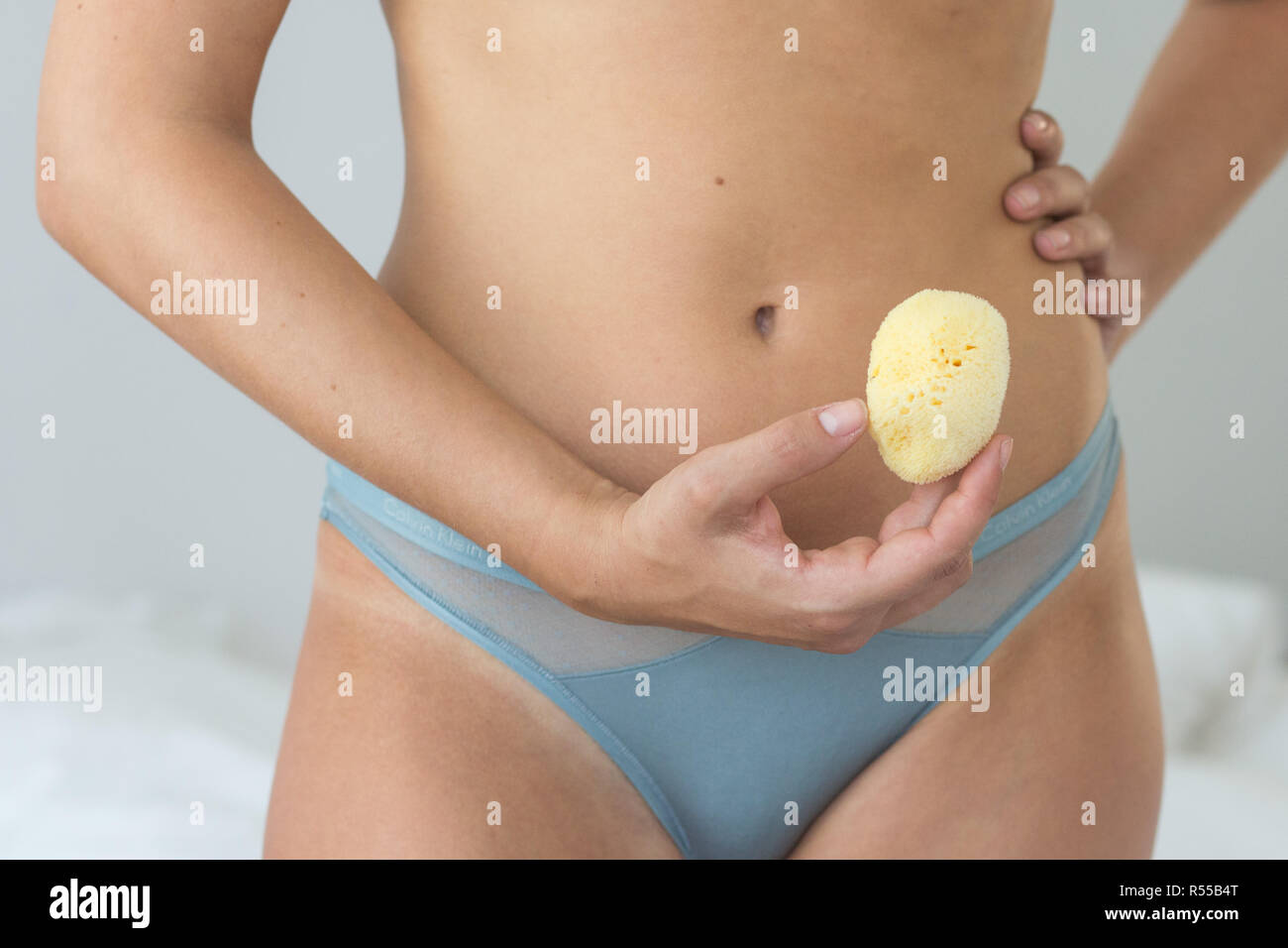 Donna che mantiene una spugna mestruale utilizzato anche come contraccettivo. Foto Stock