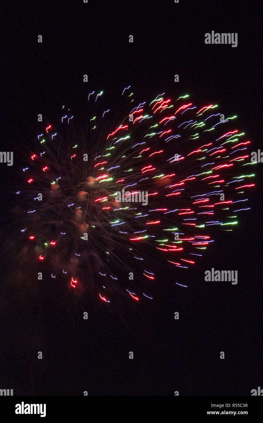 Striature di colore rosa e verde da un fuoco d'artificio lanciato off-shore in East Sussex Foto Stock