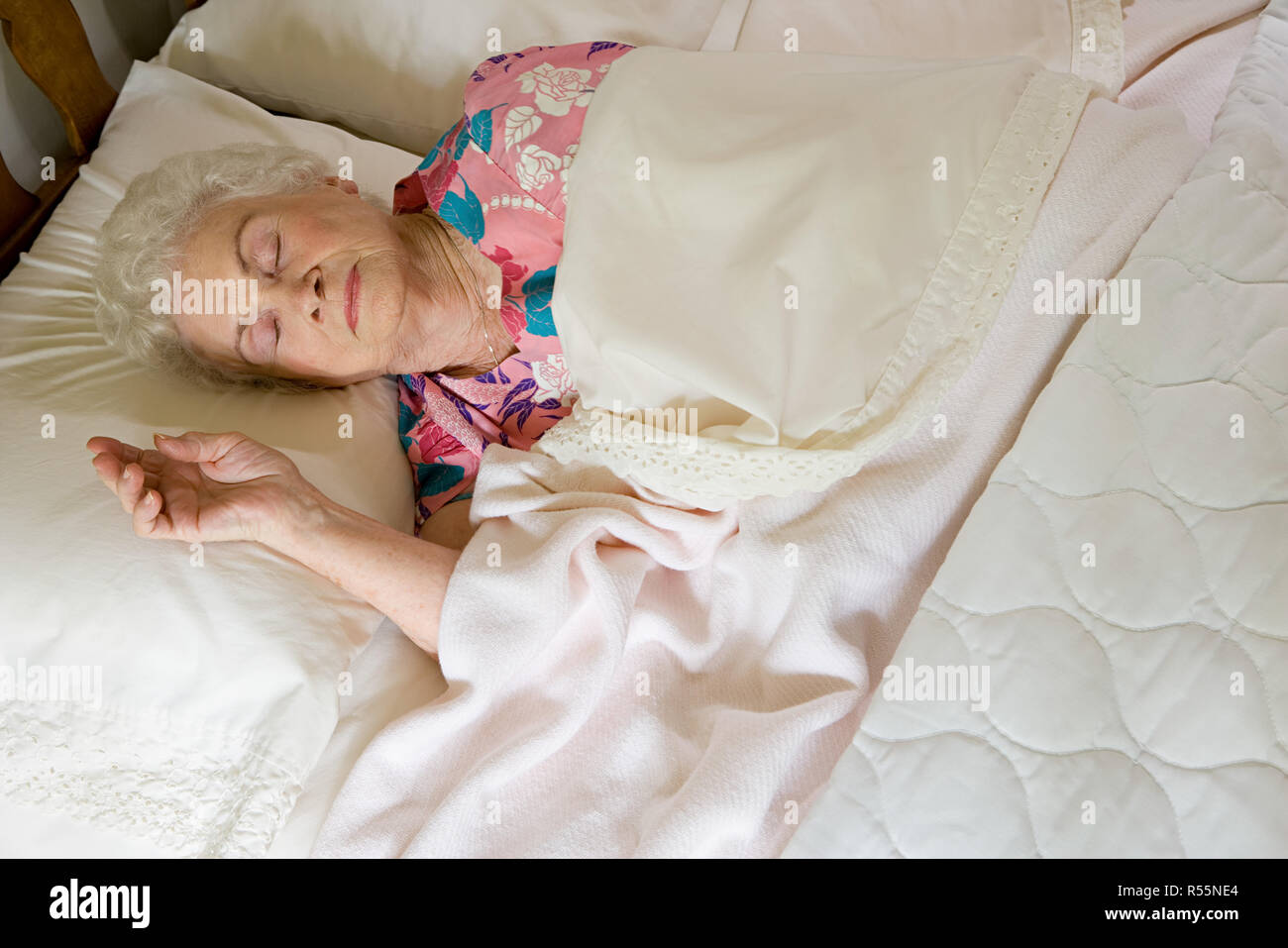 Donna anziana dorme nel letto Foto Stock