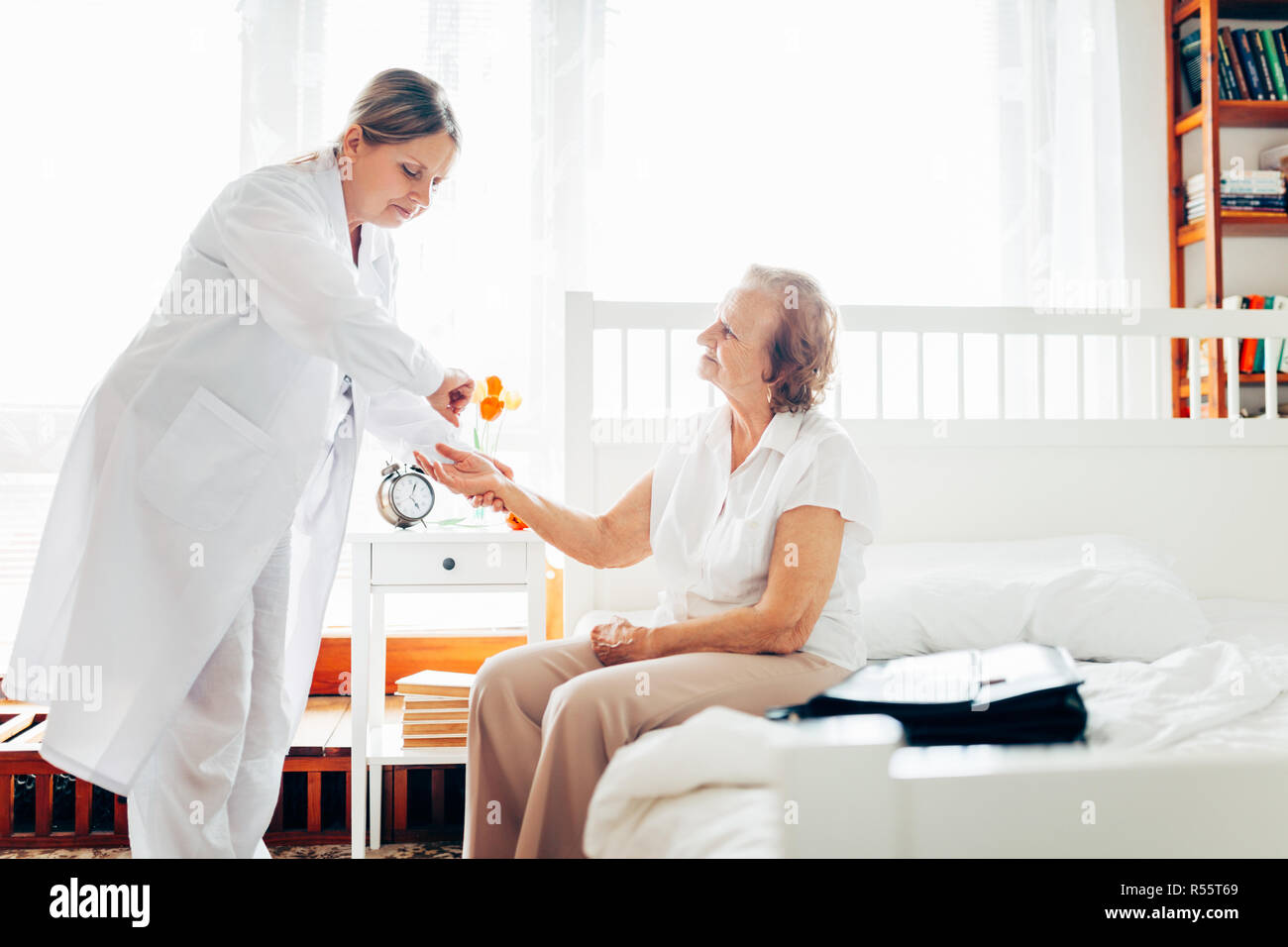 Fornire la cura per gli anziani. Visita medico paziente anziano a casa. Foto Stock