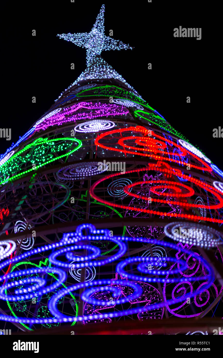 Albero di natale moderno con luci a LED di notte, foto vista bassa. Stella in alto, Valencia, Spagna Foto Stock