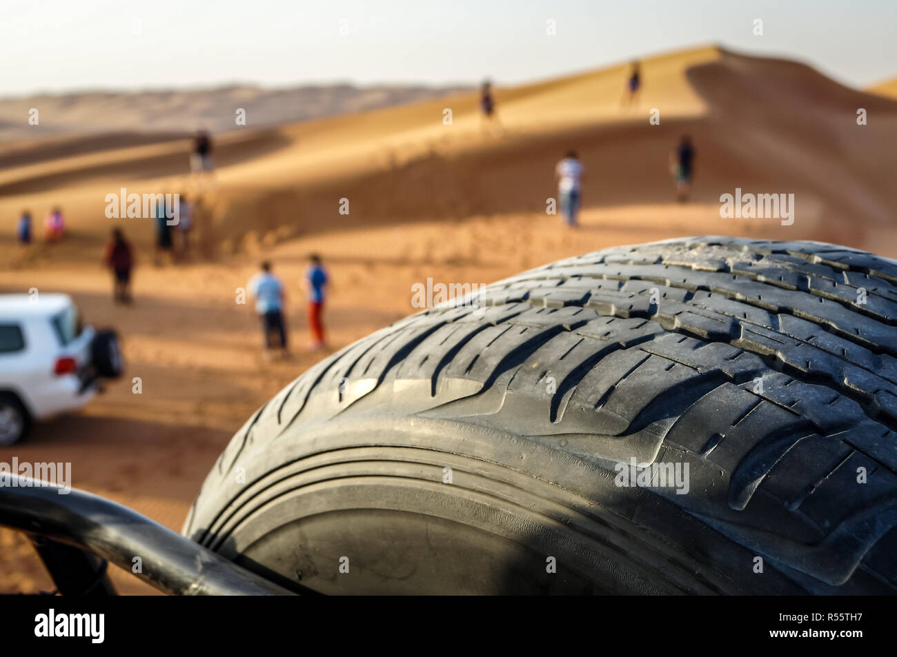 Veicolo fuoristrada safari nelle dune di sabbia del deserto di Dubai. Vista dalla vettura con la ruota di scorta e con sfondo sfocato Foto Stock