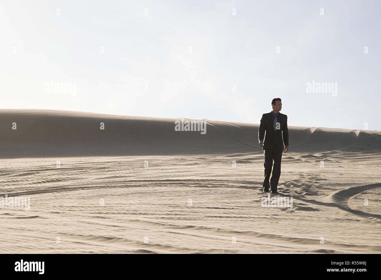 Imprenditore camminando nel deserto Foto Stock