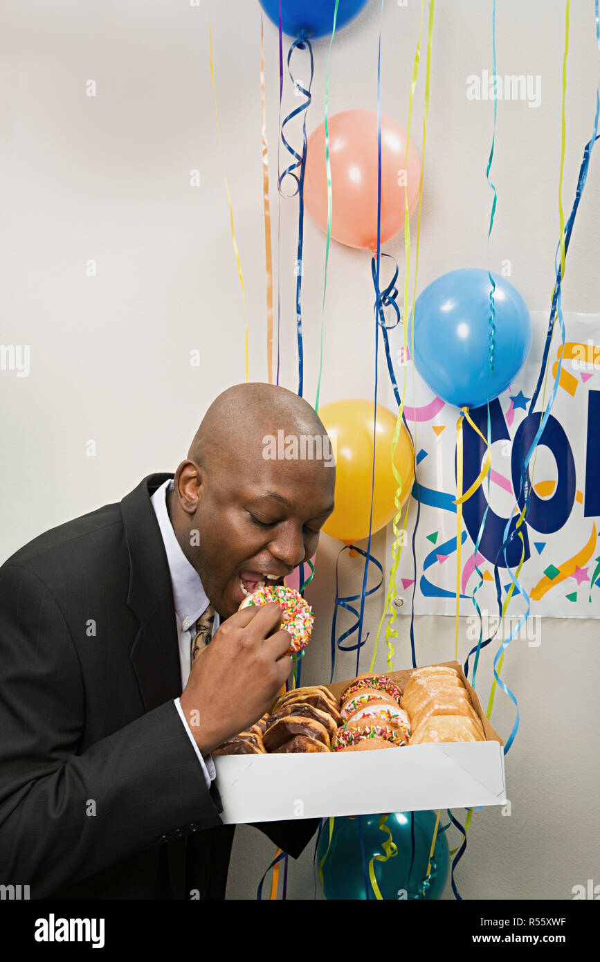 Imprenditore segretamente mangiare bomboloni Foto Stock