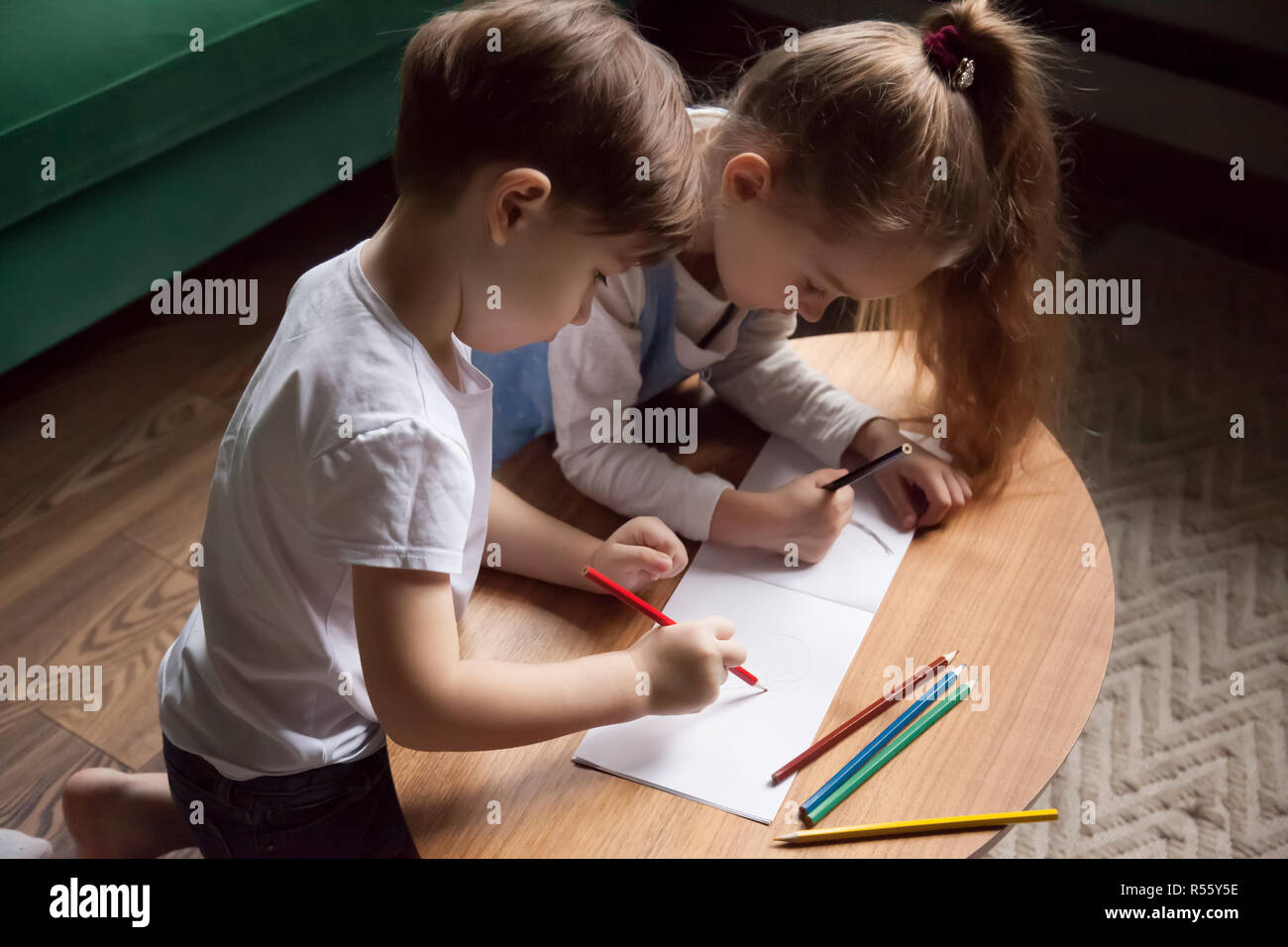 Fratello e Sorella di Disegno con matite colorate, giocando togethe Foto Stock