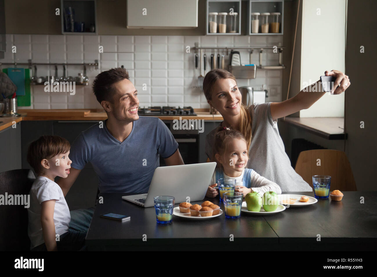 Felice grande famiglia a colazione prendendo selfie sul telefono Foto Stock