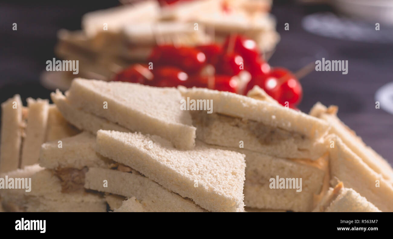 Poco cocktail panino con pomodori su una tovaglia di colore nero Foto Stock