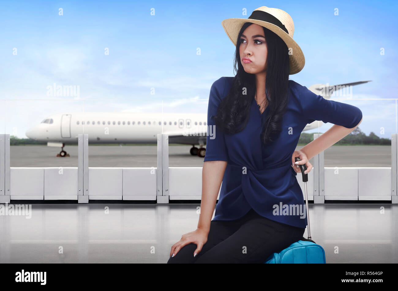 Ritratto di viaggiatori asiatici donna con la faccia triste seduto sulla valigia Foto Stock