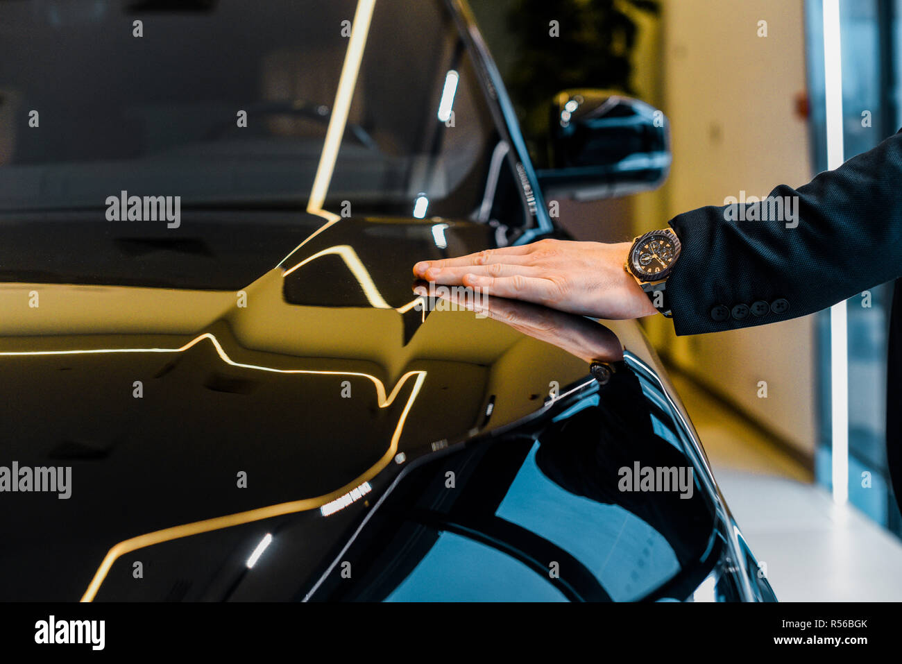 Immagine ritagliata di imprenditore con orologio di lusso scegliendo automobile nel salone della concessionaria Foto Stock