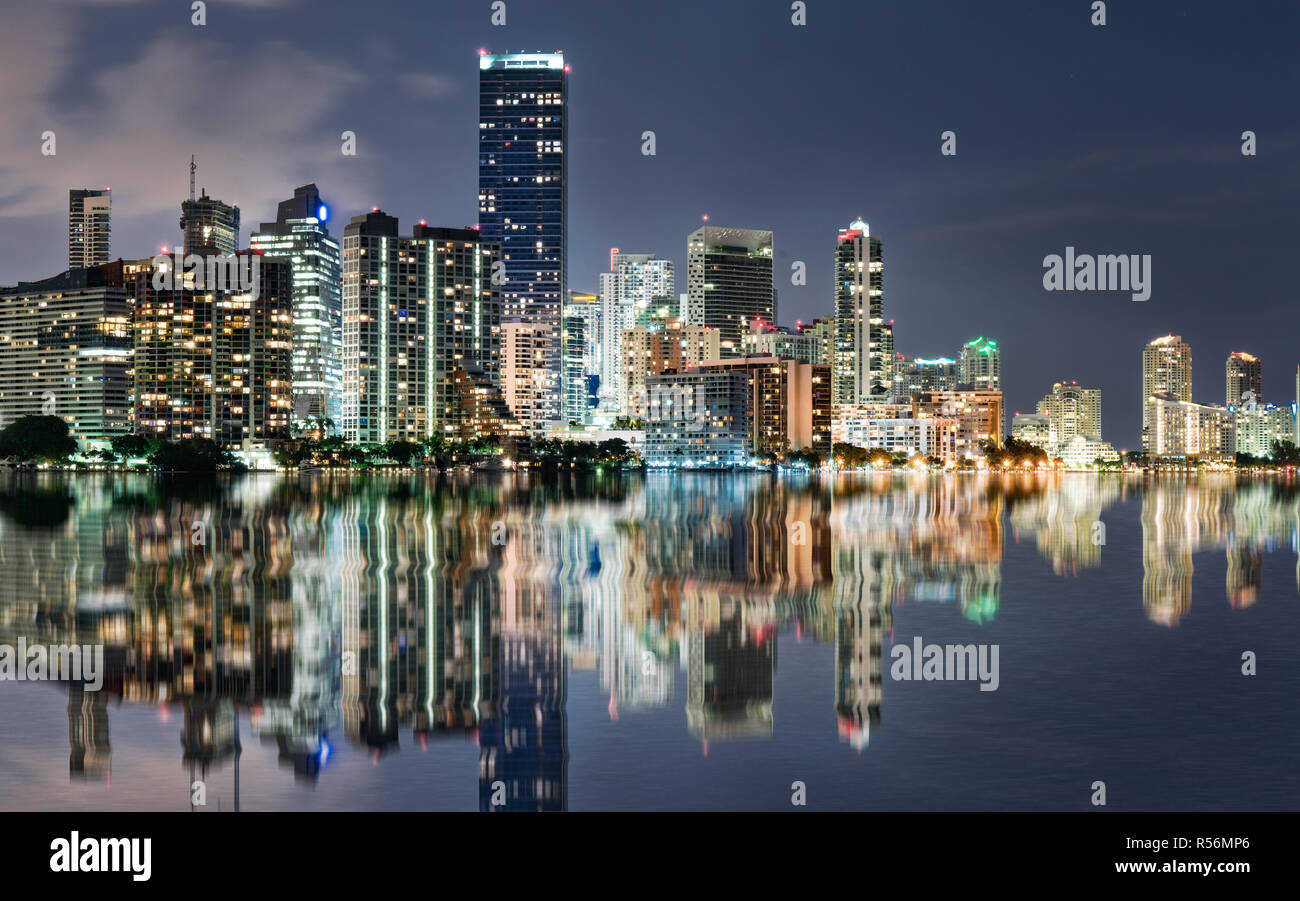 Lo skyline di Miami la riflessione di notte in tutta la baia di Biscayne dall'Rickenbacker Causeway Foto Stock