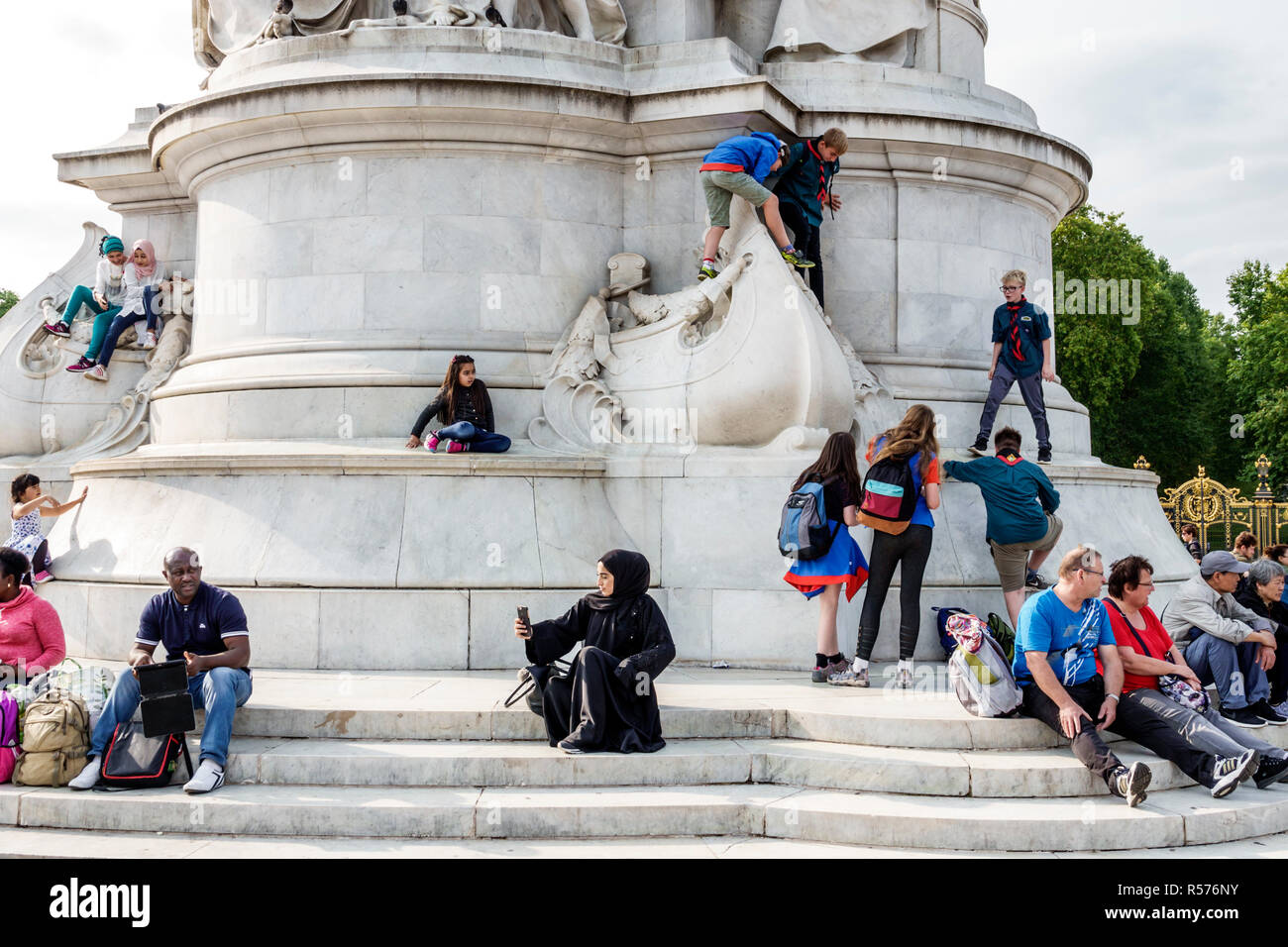Londra Inghilterra,Regno Unito,Westminster,Buckingham Palace Victoria Memorial,monumento,Black Muslim,uomo uomo maschio,donna femmina donne,bambini che giocano a arrampicata,sitt Foto Stock