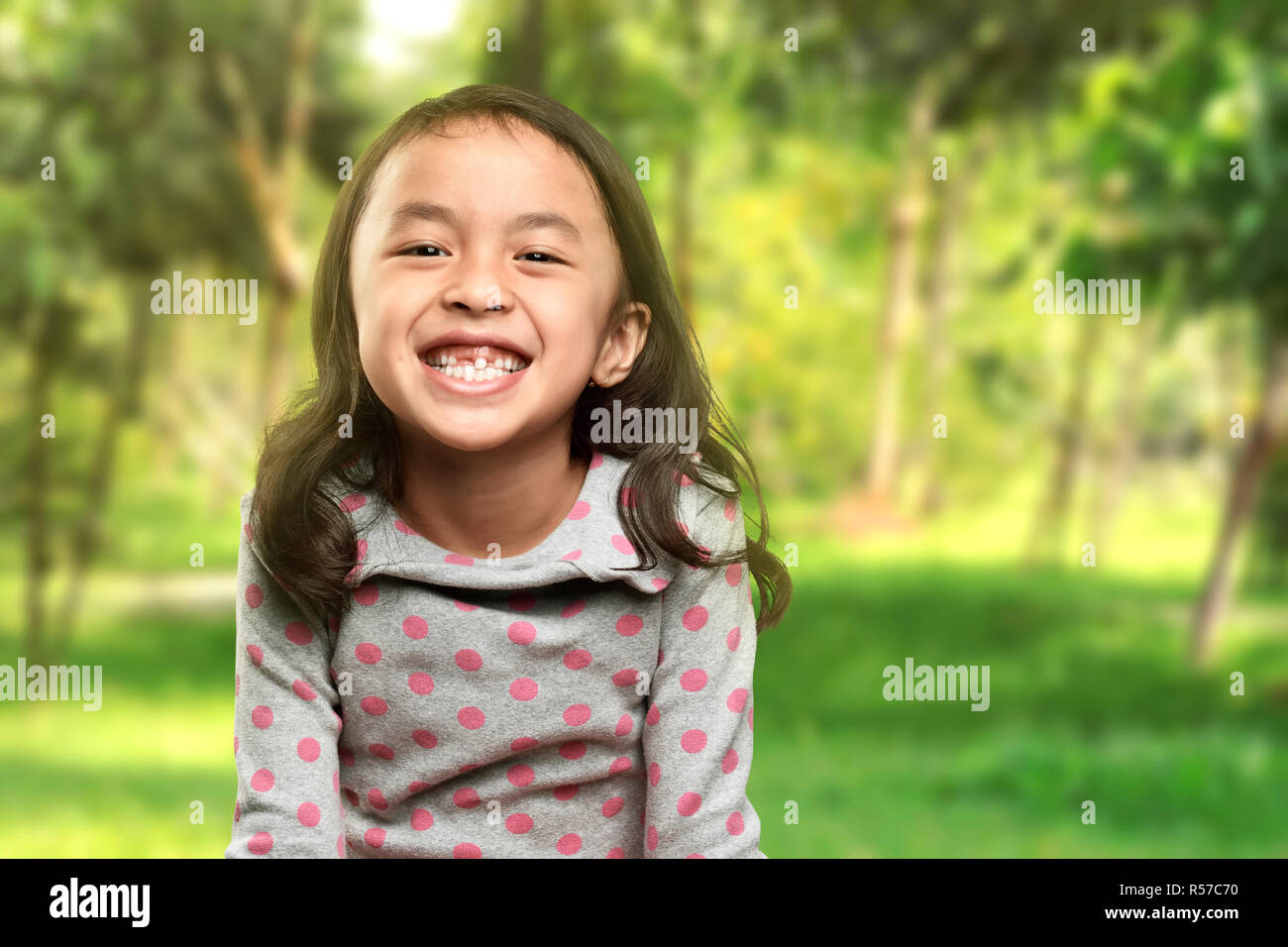 Funny asian bambina sorriso con il suo dente rotto Foto Stock