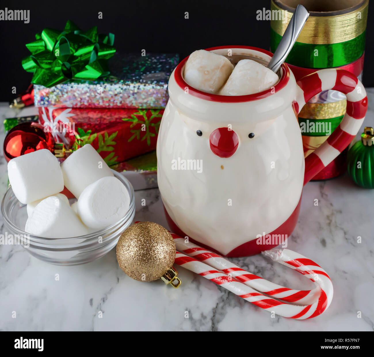 Babbo Natale tazza con cioccolata calda & Marshmellows con la caramella canne e bastoni di menta piperita presenta fiocchi di raso e Marshmellows fresco Foto Stock