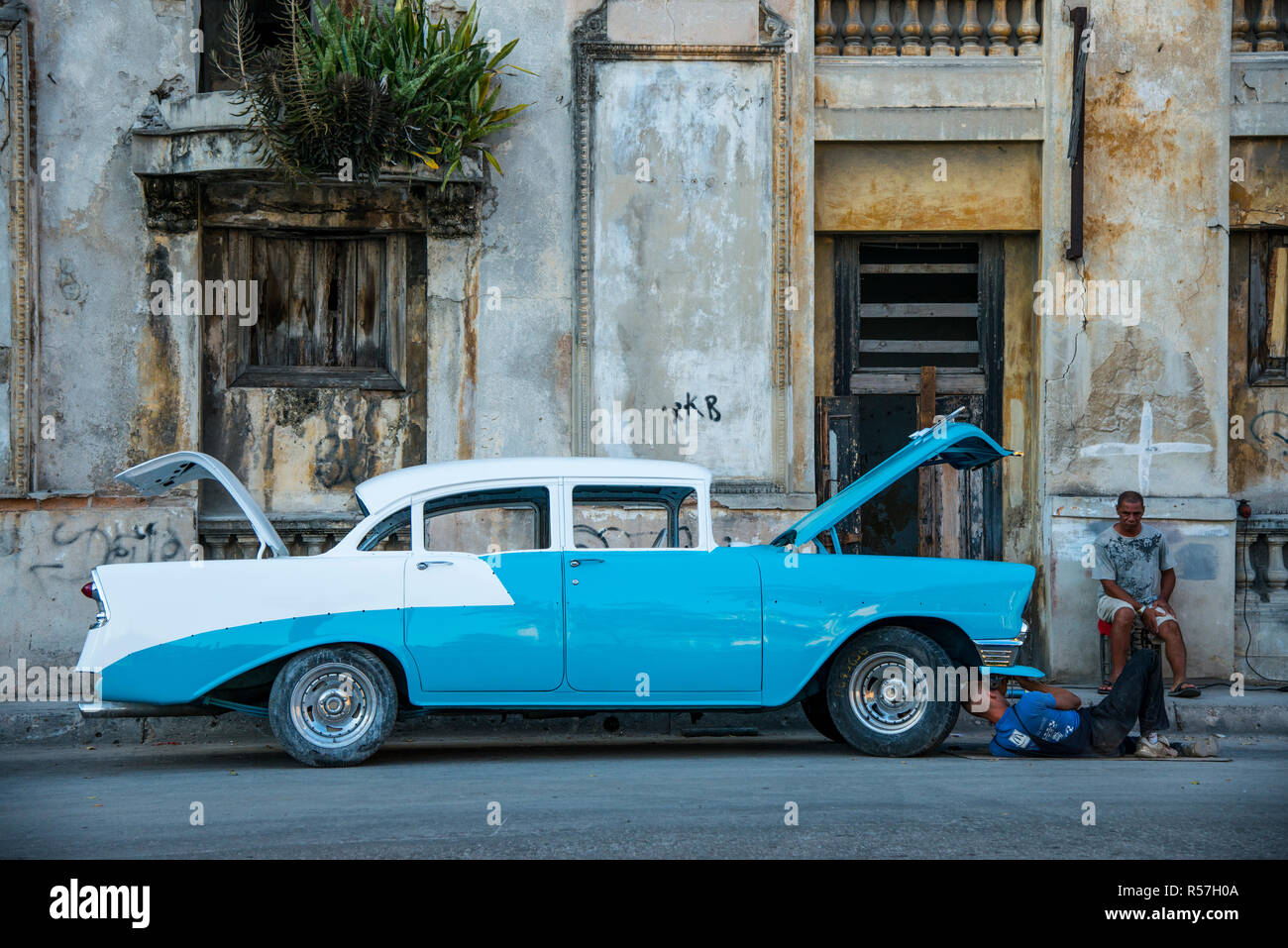 Uomo che ripara la vecchia auto in Havana Foto Stock