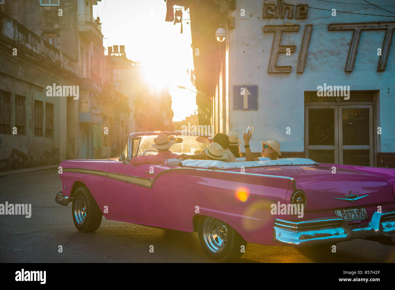 Rosa convertibile Ford Fairlane con turisti per un sunset drive. Foto Stock