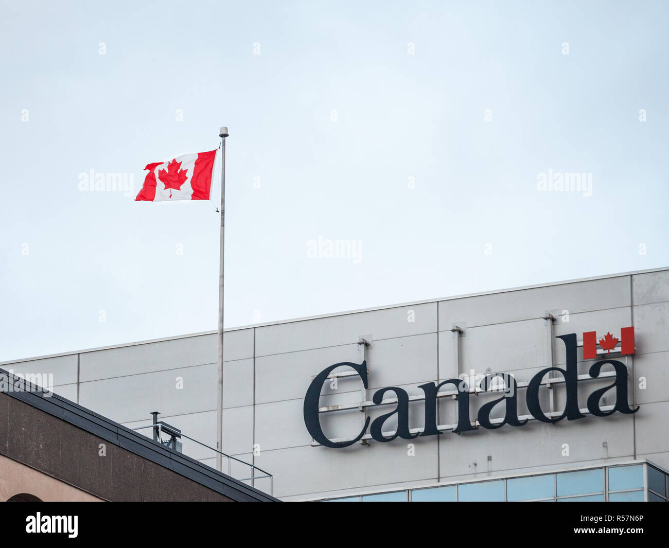 OTTAWA, Canada - 10 novembre 2018: Canada del logotipo, il logo ufficiale del governo canadese, su di un edificio amministrativo accanto a un canadese fl Foto Stock