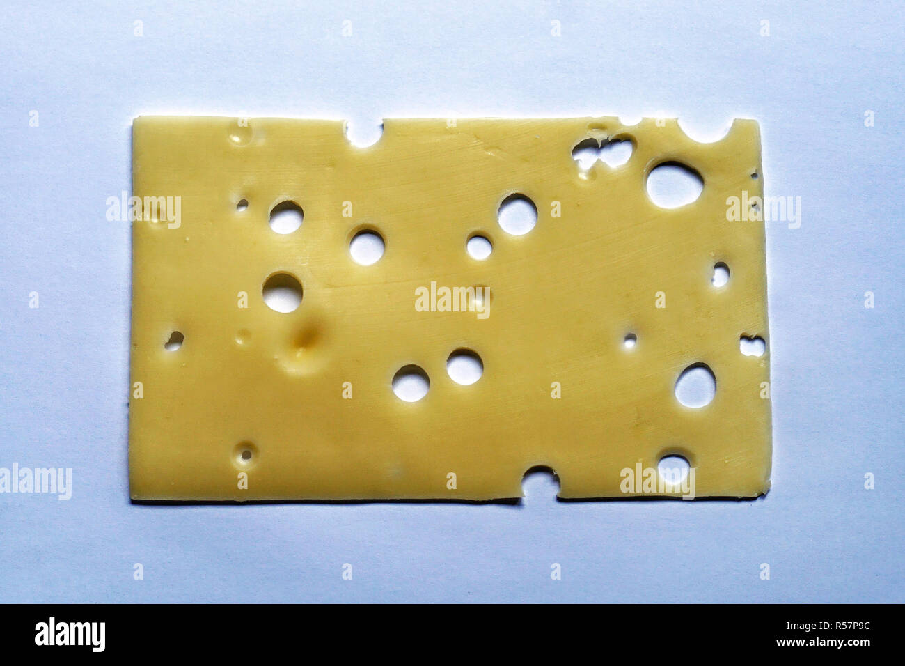 Una fetta di formaggio emmenthal con fori Foto Stock