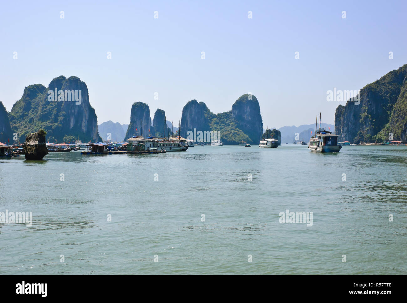 Le imbarcazioni turistiche a floating villaggio di pescatori nella baia di Halong, Vietnam Foto Stock