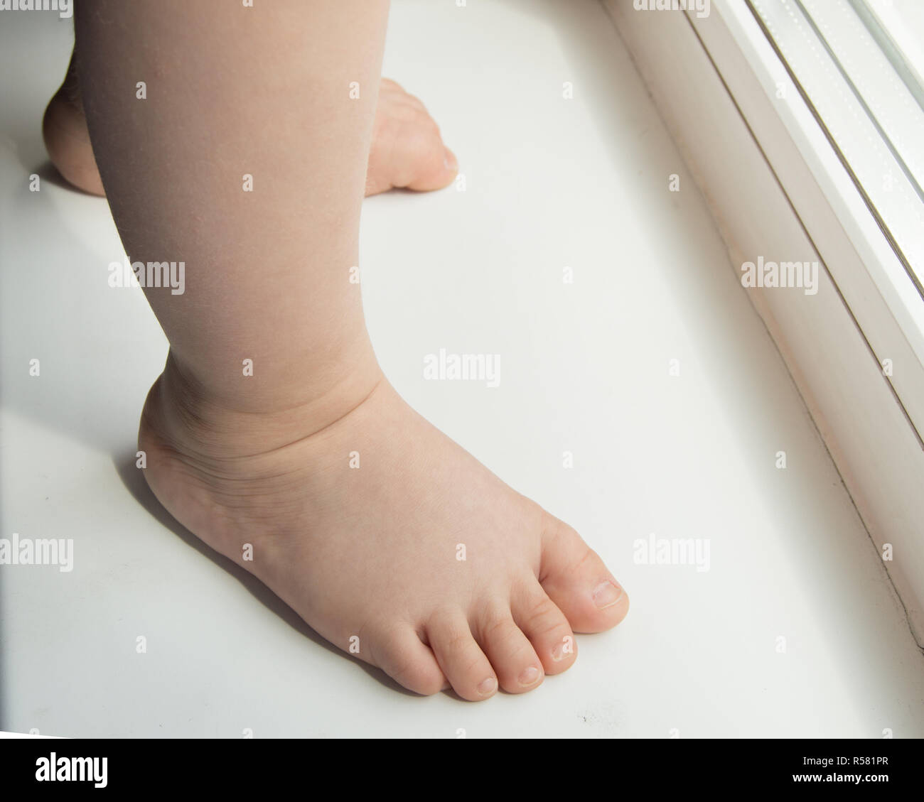 Adorable baby little feet stand, primi passi, close-up Foto Stock