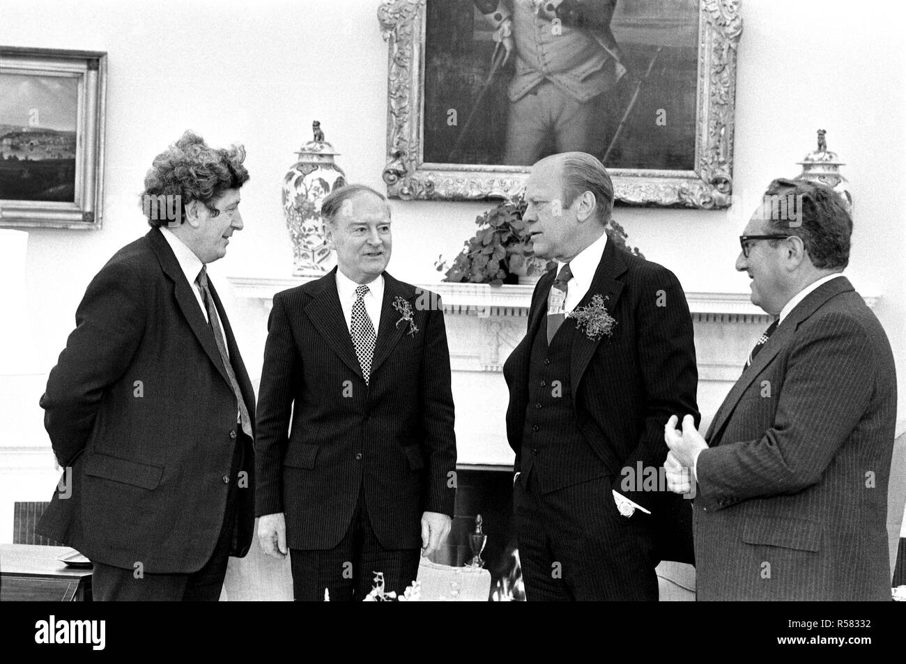 1976, marzo 17 - Sala Blu - La Casa Bianca - Gerald Ford, Liam Cosgrave, Garret FitzGerald, Henry Kissinger - standing, parlando vicino al camino Foto Stock