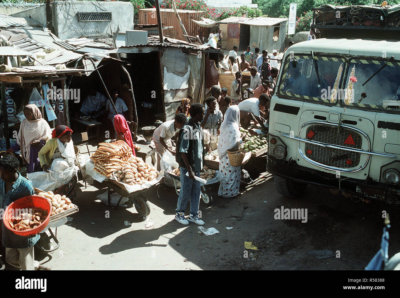 1992 - fornitori di somali velo la loro mercanzia su una strada trafficata durante la multinazionale soccorsi Restore Hope. Mogadiscio (Somalia) Foto Stock