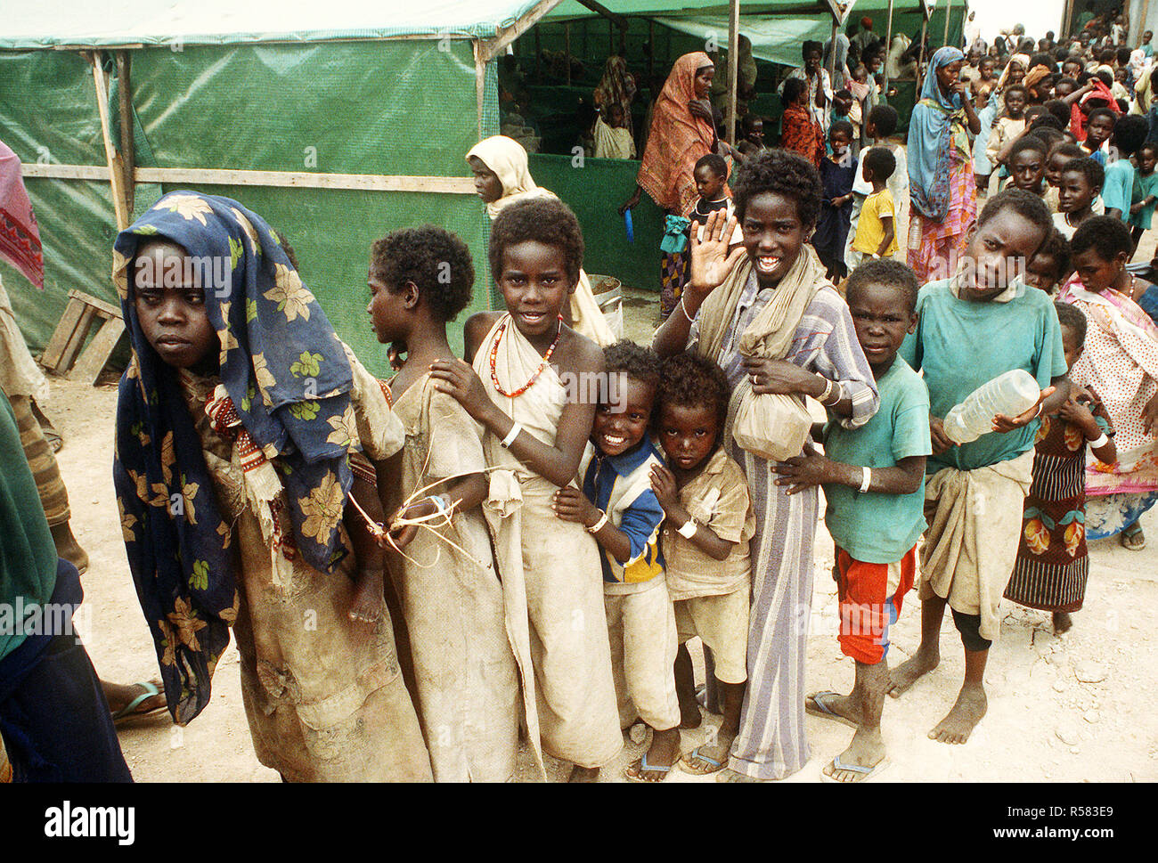 Bambini stare in linea in corrispondenza di una stazione di aiuto durante la multinazionale soccorsi Restore Hope. Foto Stock